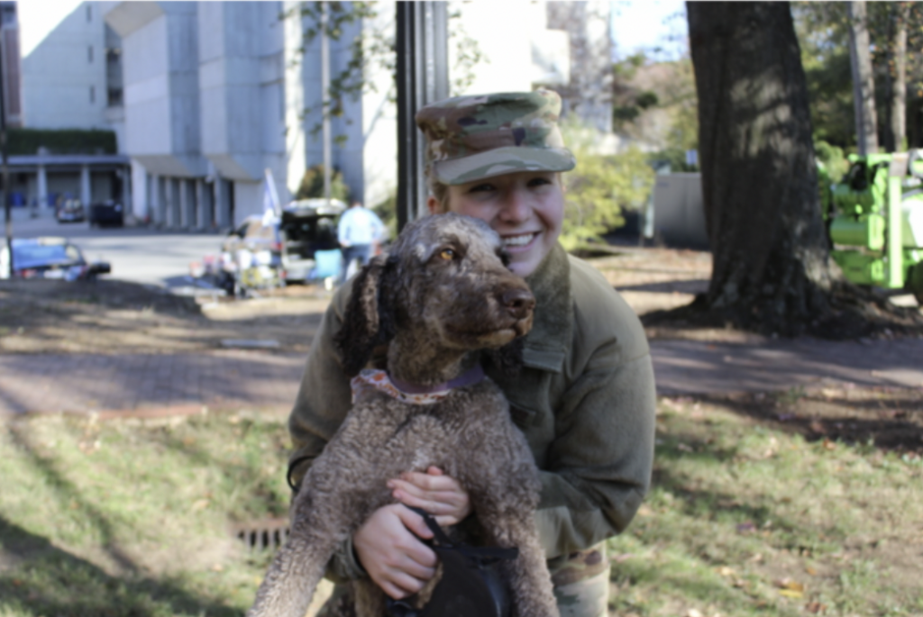 A cadet poses with her dog. 